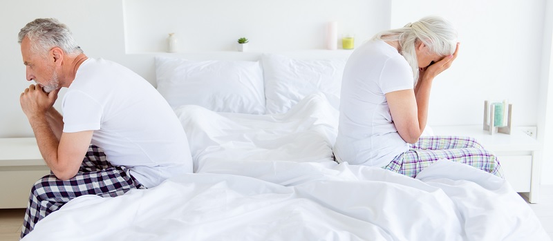 Un couple dos à dos dans un lit.